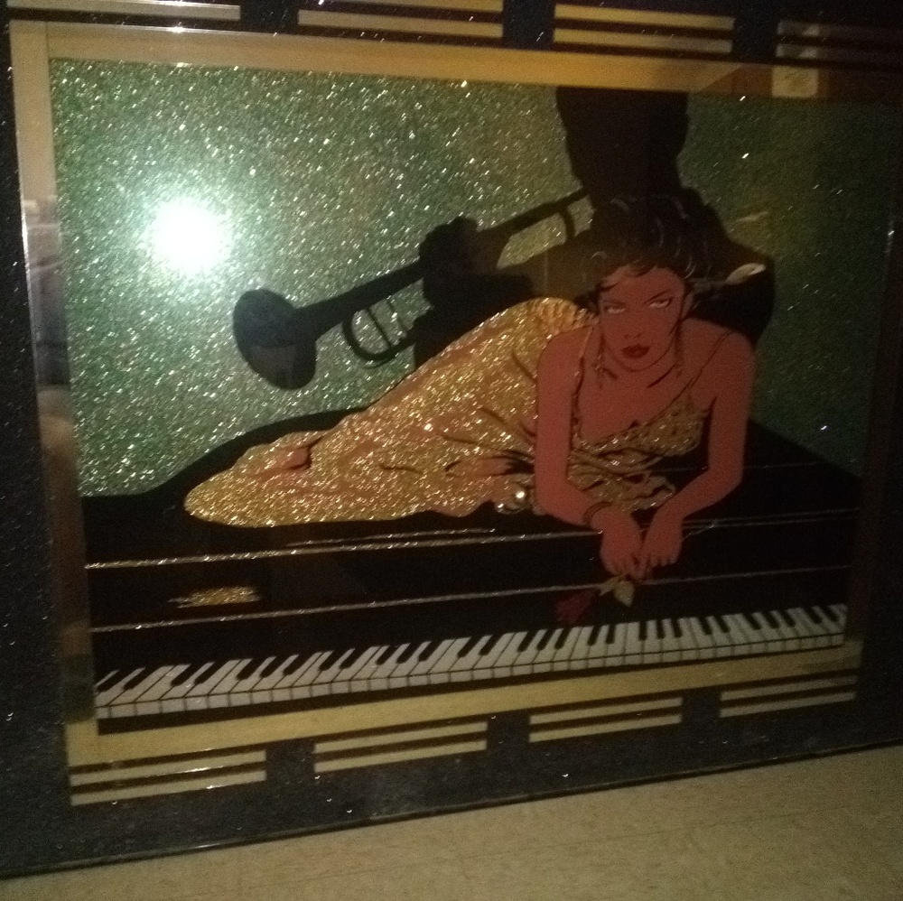 Art wall. A woman on top piano a guy playin a trum
